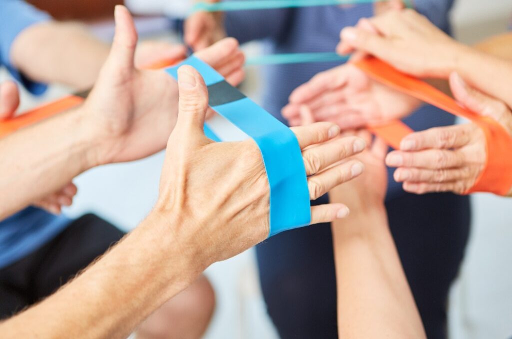 Die Hände machen Übungen mit dem Gummiband