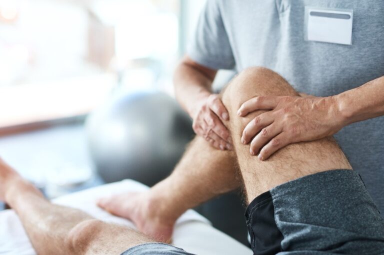 Gesundheits-, Knie- und Physiotherapeut mit männlichem Patienten in der Klinik zur Heilung, Rehabilitation oder Behandlung. Physiotherapie, Dehnung und medizinischer Mitarbeiter mit Sportler für Beinverletzung oder Unfallheilung