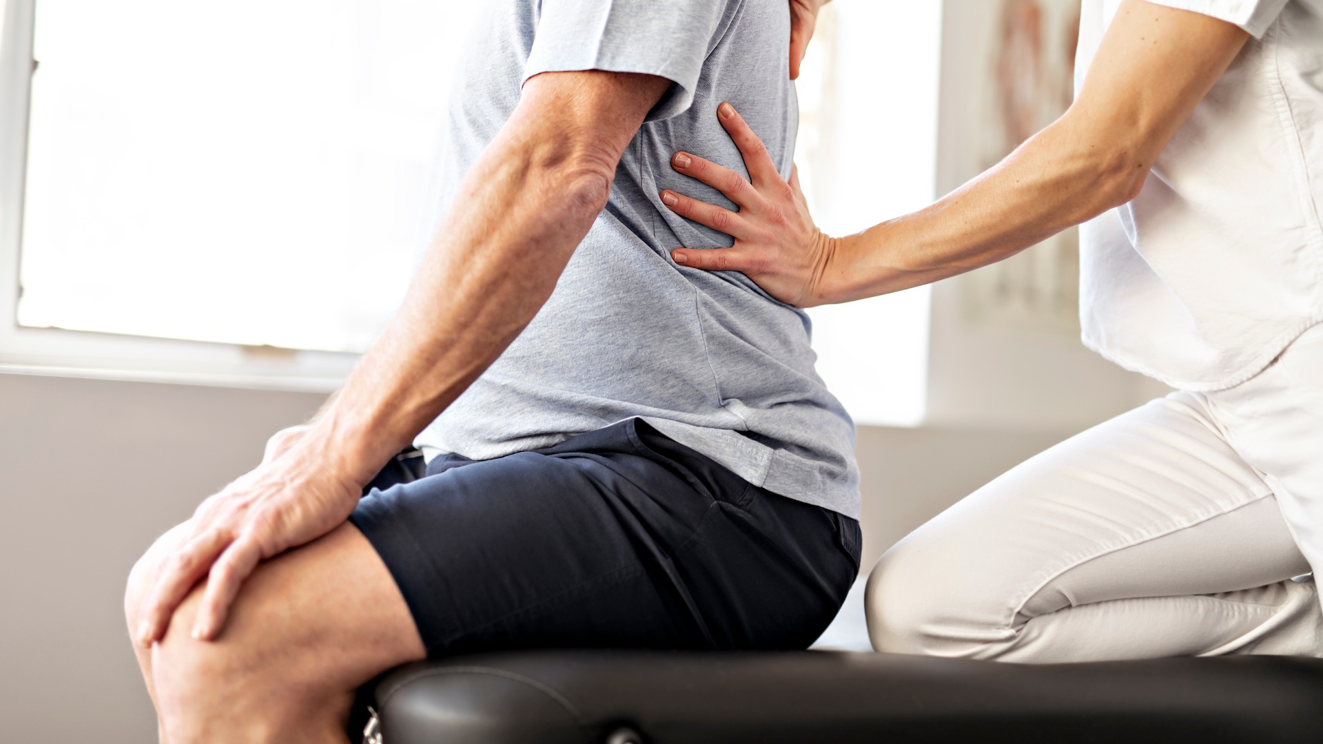 Ein Mitarbeiter der modernen Rehabilitationsphysiotherapie mit einem älteren Kunden